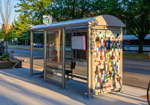 Bus Shelter Located on Grand River with mural of many people on the side.